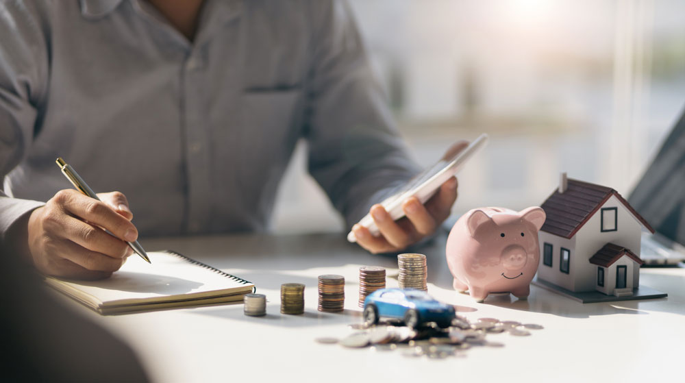 Mann checkt Finanzen mit Taschenrechner Privatkredit